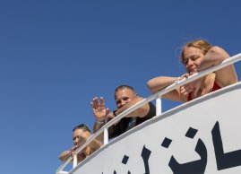Turysci obserwują z górnego pokładu statku płynącego diugonia 